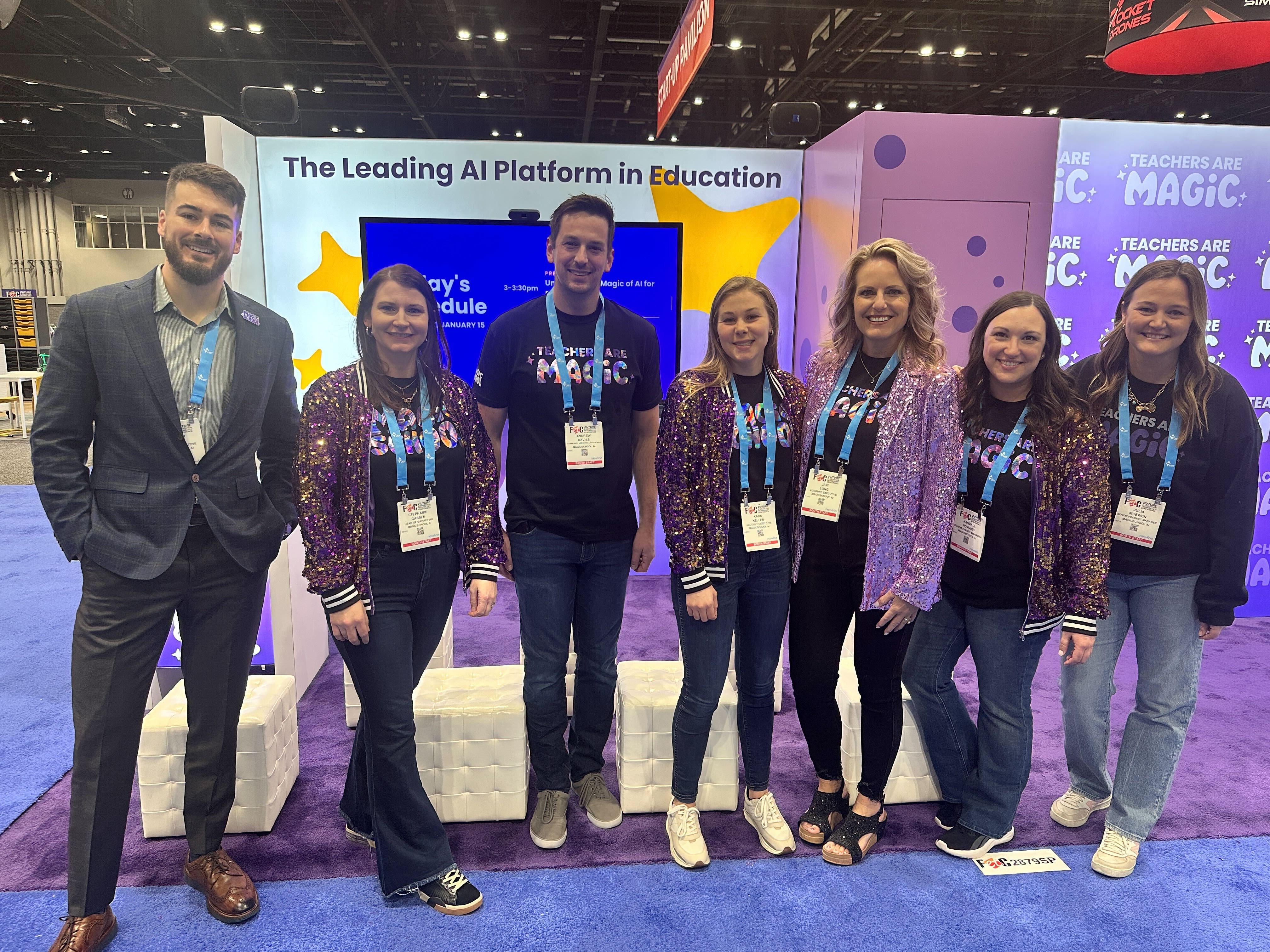 7 MagicSchool employees in branded clothing posing for group photo in front of MagicSchool's booth at a conference 